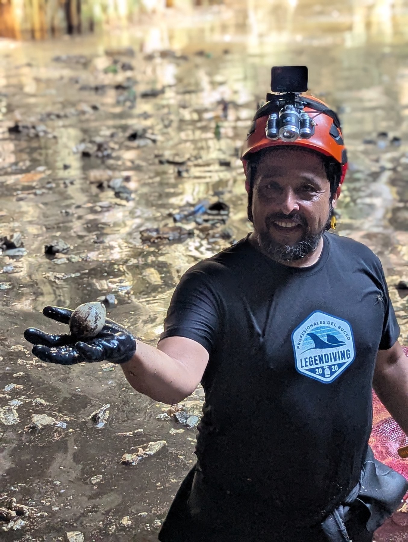 Especialista con casco y equipo de protección durante una limpieza de cenote